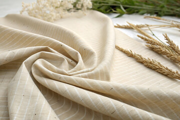 A heart shaped pillow and a heart shaped cookie rest gently on a clean white towel atop a rustic wooden background