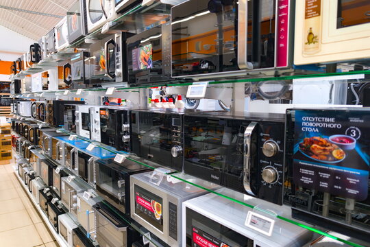 Store displays various kitchen appliances including microwaves in a retail setting in a busy shopping area