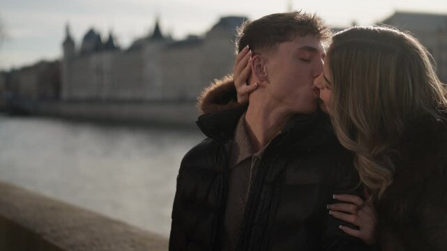 A romantic couple is kissing in Paris France with the Seine River and cityscape in the background The clip captures a moment of love and affection in Europe showcasing travel and romance Close up shot