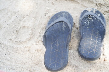 black flip flops isolated on white sand beach.photo from above