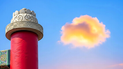 Ancient temple pillar stands beneath a vibrant cloud against a serene blue sky at sunset