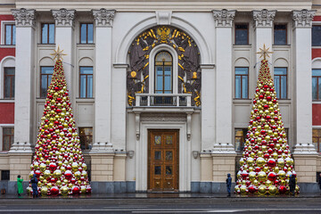 Moscow, Russia - 30 December 2025: Facade of classical building with two giant Christmas trees made of red and gold baubles,  Moscow government building, city hall.