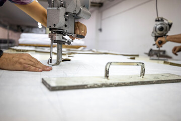 Tailor using vertical electric cutter for military textile