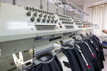 Professional embroidery machine heads stitching black fabric