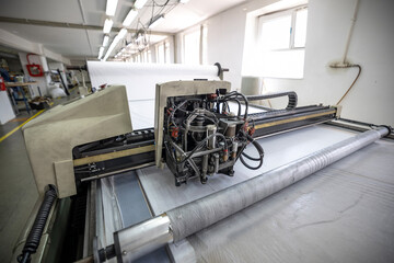 Close up of CNC cutter head processing white textile