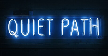 Bright neon sign displays words Quiet Path. Dark blue glow contrasts wood paneling. Minimalist aesthetic, simple message.