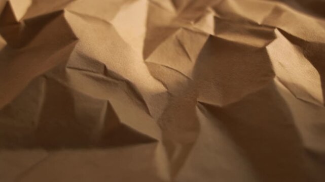Crumpled brown kraft paper with irregular folds and creases