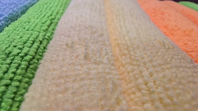 Macro close-up of soft microfiber fabric textures in various colors showing fiber details and stitching