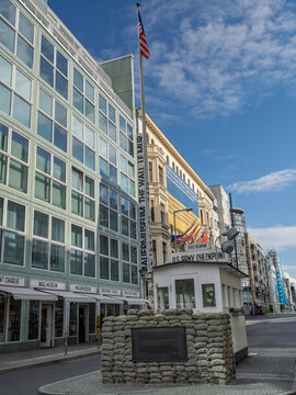 American Flag Flying Over Checkpoint Charlie Historic Guardhouse And Museum Building - Berlin, Germany