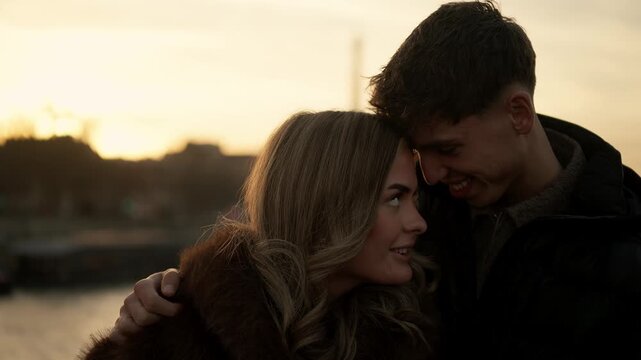 A young couple embraces in Paris France during sunset The golden hour lighting creates a warm and romantic atmosphere as they share an intimate moment The clip showcases love and affection in a Europe