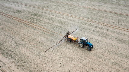 tractor treats field with pesticides top view © Polivan