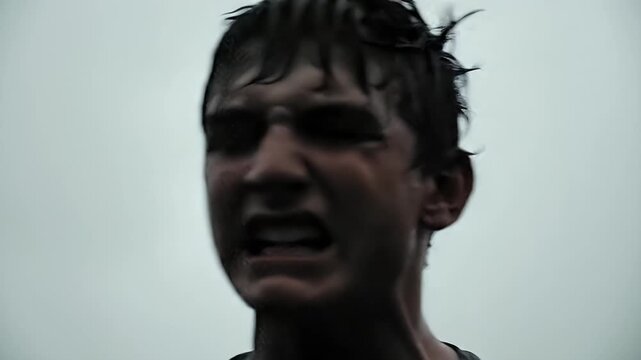 Intense Close-Up of a Determined Young Man's Face, Showing Drive and Resilience, filmed outdoor