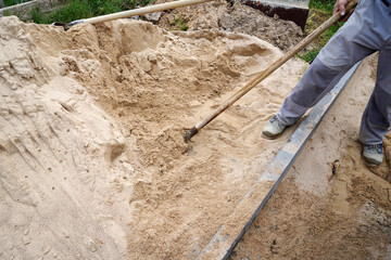 working with a shovel pours the gravel.