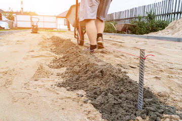 a worker prepares a platform for laying paving slabs in the defocus.