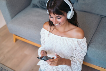 Happy woman listening to music streaming with headphones