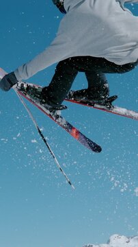 SLOW MOTION, CLOSE UP: Male freestyle skier takes off a kicker and does a challenging 360 grab while riding in the snowpark of , Slovenia. Spectacular shot of a man doing an extreme skiing trick.
