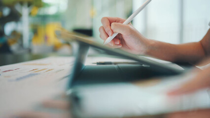 Close-up of a hand using a stylus on a tablet, creative digital design