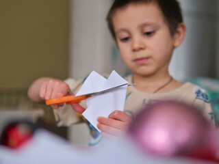 Boy Using Orange Scissors for Paper Crafting to Develop Fine Motor Skills