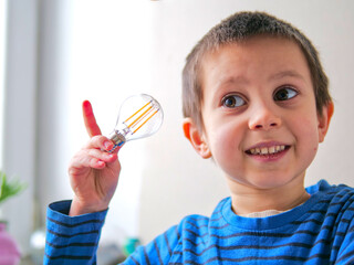 Enthusiastic Young Boy with Excited Expression Holding Lightbulb Representing a Brilliant Idea - fostering creativity, curiosity, and critical thinking