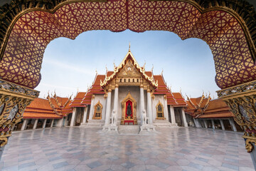 Wat Benchamabophit temple framed by ornate archway in Bangkok, Thailand