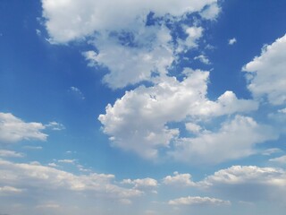 Beautiful bright blue sky background with fluffy white cumulus clouds