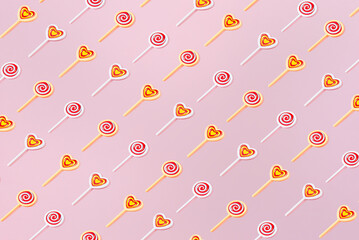 Creative pattern round heart lollipop flat lay pastel pink background minimalism