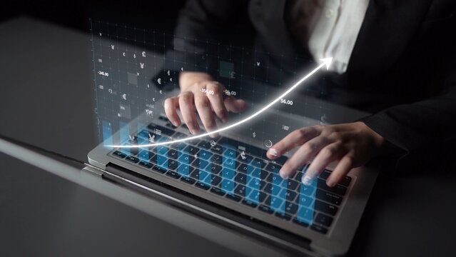 A focused business professional types on a laptop while a digital graph displaying upward growth trends overlays the scene, embodying financial success and strategic planning. Copula - Powered by Adobe