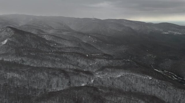 Snowfall over snow-covered mountains, creating a dramatic winter landscape as snowflakes fall across rugged peaks. The scene evokes cold weather, serenity, and the raw beauty of nature during winter, 