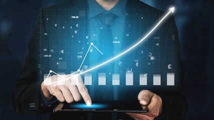 A businessman uses a touchscreen tablet to analyze financial growth trends with dynamic graphs. This image captures technology and innovation in a professional work environment. Copula
