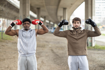 Two boxers raise their arms in triumph, celebrating friendship and sportsmanship after a successful sparring session.