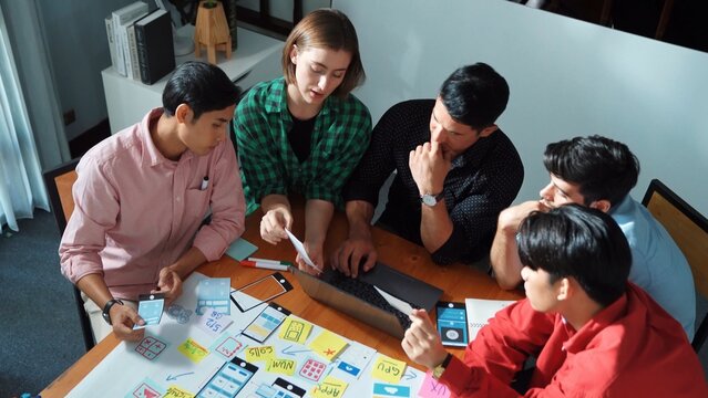 Top view of diverse business people brainstorming idea by using mind map. Creative marketing team looking at data analysis from laptop screen while manager choose idea and show to team. Convocation. - Powered by Adobe