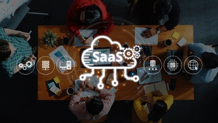 A diverse group of professionals collaborates in a modern workspace, discussing software as a service ideas with digital tools and charts on a table. Raster