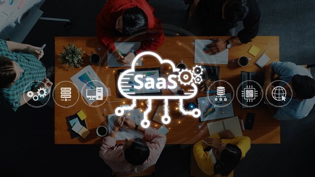 A diverse group of professionals collaborates in a modern workspace, discussing software as a service ideas with digital tools and charts on a table. Raster - Powered by Adobe
