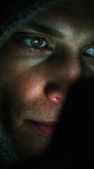 Obraz premium Close-up of a face lit by a smartphone screen in a dark room, expression of digital addiction