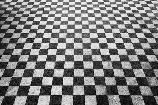 Black and white checkerboard floor in perspective. Abstract checkered tile pattern background. Vector horizontal chess board grid plane surface. Retro vintage empty ball room checker floor