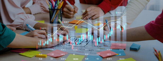 Hands of diverse individuals engaged in teamwork around a desk filled with sticky notes, as financial charts and graphs overlay the scene, showcasing business analysis. Scalp