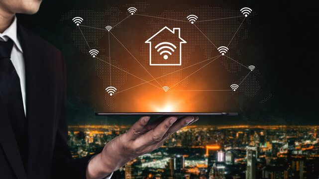 A businessman showcases a tablet depicting a smart home network concept, emphasizing digital connectivity and modern technology against a vibrant cityscape backdrop. Gantry - Powered by Adobe