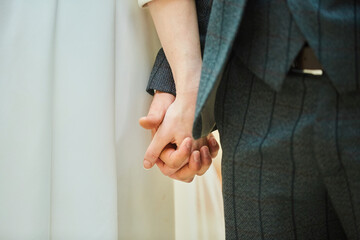 The hands of a young couple at a wedding.