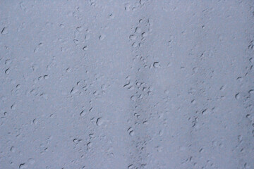 Transparent plastic texture with water drops. Transparent white plastic background. Wet transparent polyethylene film with droplets of water after rain. Water drops close-up.