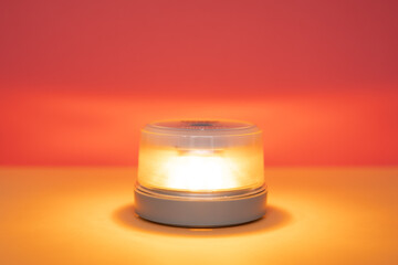 v16 beacon Portable emergency signal light glowing on warm background