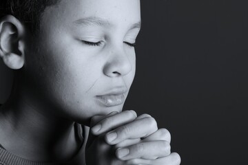 little boy praying to God with hands together with people stock image stock photo 
