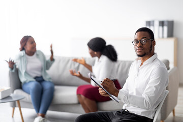 Young black psychologist and angry black LGBT couple fighting during session at office, copy space....