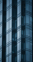 Obraz premium Close-up of glass facade, showcasing a modern building's geometric design, reflecting light and shadow, symbolizing corporate strength and urban development