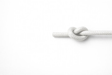 A white rope with a knot on a white background. Space for text.