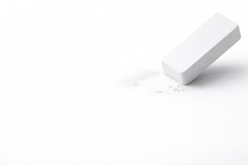 White eraser with crumbs on a white background. Space for text.