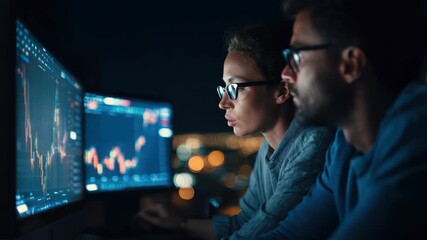 Business professionals monitor stock market trends on computer screens during a night session in an urban setting - Powered by Adobe