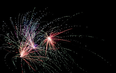 Lively display of twin fireworks bursting with colorful sparks and lively confetti trails