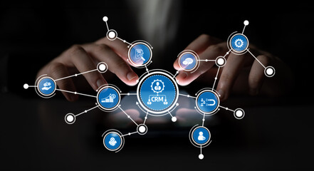 Close-up of hands interacting with a touchscreen displaying innovative CRM icons representing various business applications and data management solutions. Crux