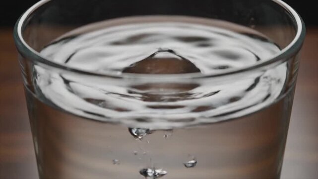 Close-Up of Water Droplet Falling into Glass.