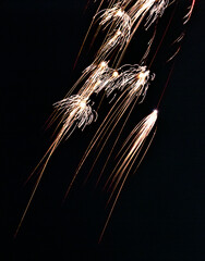 Cinematic shot capturing fiery trails and sparkling fragments against moody night backdrop